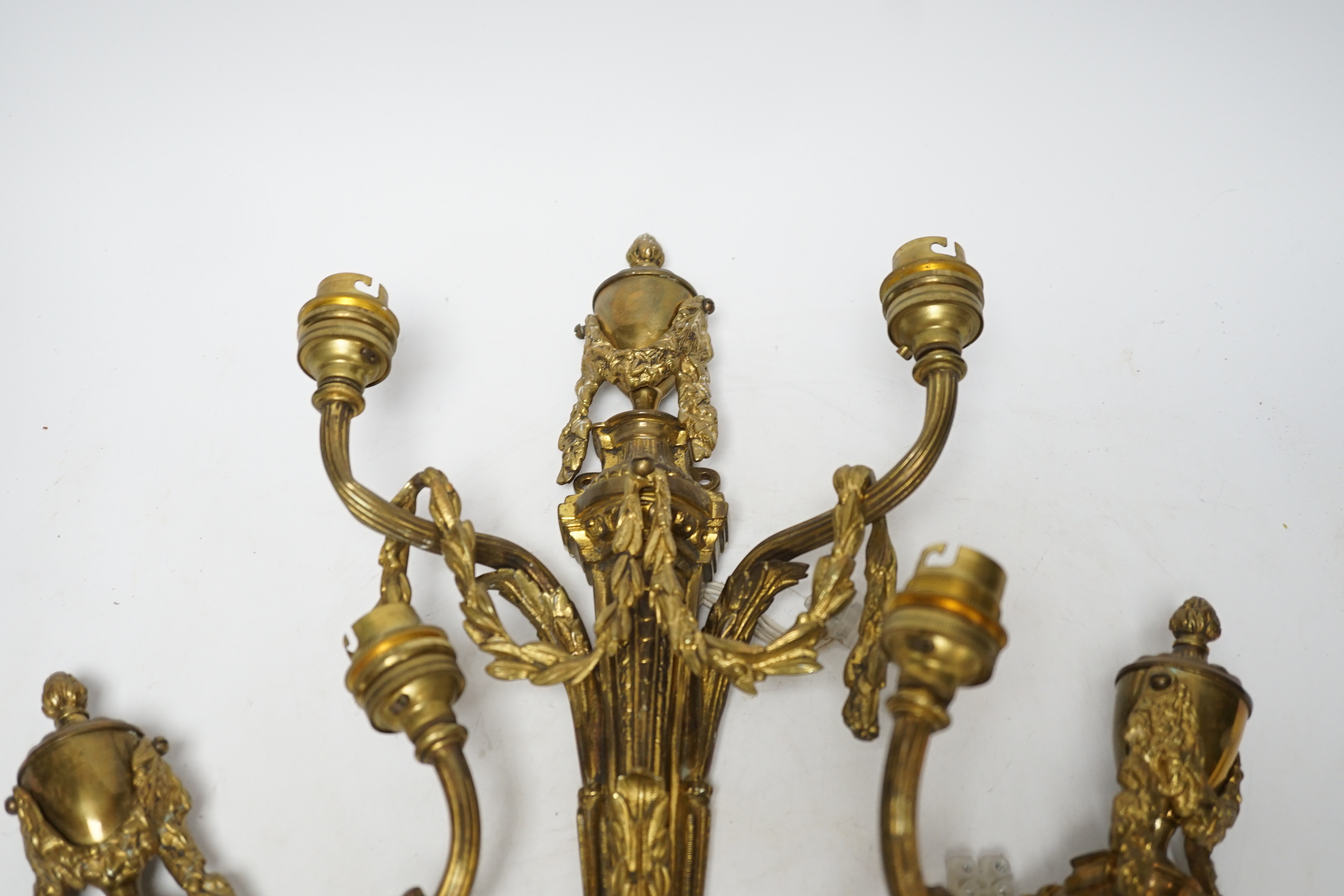 A set of three Louis XVI style two branch ormolu wall lights, 38cm high